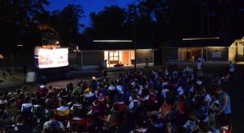 Airy campers watching an outdoor movie