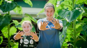 Girls gardening and holding out their hands