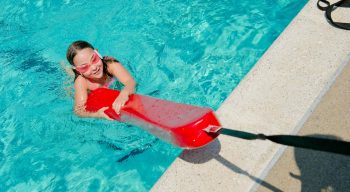 Girl holding onto lifeguard floatation device